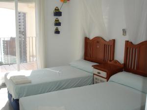 two twin beds in a room with a window at VillaMarina Apartments - Zand Properties in Benidorm