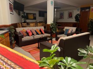 uma sala de estar com sofás, mesas e plantas em Chinchero Boutique Hotel & Tours em Chincheros