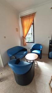 um quarto com cadeiras azuis, uma mesa e uma janela em Villas Dalia NA4/11 em Cianjur