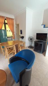uma sala de estar com uma cadeira azul e uma mesa em Villas Dalia NA4/11 em Cianjur