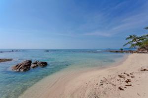 a beach with two rocks in the water at ShaSa Resort - Luxury Beachfront Suites in Lamai