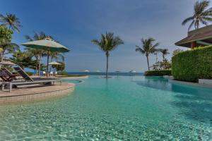 ShaSa Resort - Luxury Beachfront Suites في شاطئ لاماي: مسبح في منتجع فيه نخل