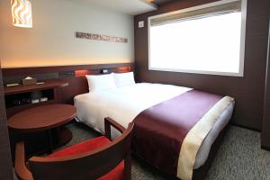 a hotel room with a bed and a small table at Urban Hotel Kyoto Shijo Premium in Kyoto