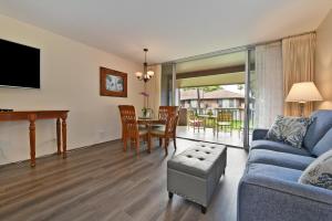 a living room with a blue couch and a table at Eldorado J209 in Kahana