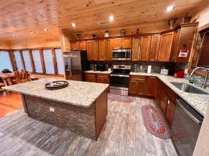 a kitchen with wooden cabinets and a counter top at Blaze of Glory - New Luxury, 4BR, Theater, Arcade, EVC, Location in Sevierville