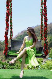 Anachal的住宿－Mistey Valley Munnar，坐在秋千上的绿色女装