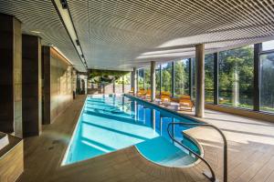 a swimming pool with chairs and tables in it at Hotel Mitland in Utrecht