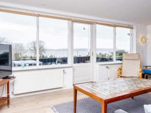 a living room with large windows and a table at 6 person holiday home in B rkop in Børkop