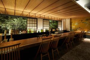 a restaurant with a long wooden table and chairs at Villa Ryusei in Ugata