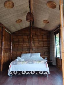 a bed in a room with a wooden ceiling at Tukus in Villeta
