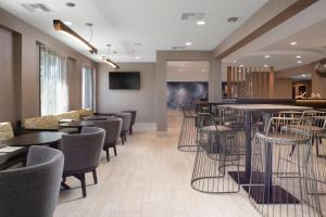 un restaurante con sillas y mesas y un bar en SpringHill Suites by Marriott Little Rock, en Little Rock