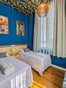 um quarto azul com duas camas e uma janela em Hotel Boutique Ayni em Guaporé