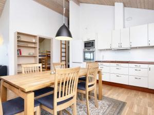 eine Küche und ein Esszimmer mit einem Holztisch und Stühlen in der Unterkunft 8 person holiday home in B rkop in Egeskov