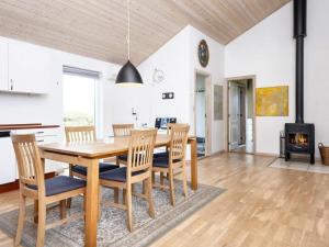 cocina y comedor con mesa de madera y sillas en 8 person holiday home in B rkop, en Egeskov