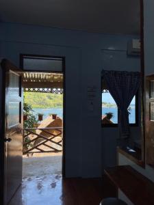 a door to a room with a view of the water at Camiguin Blue Lagoon Cottages in Mahinog