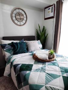 a bedroom with a bed with a clock on the wall at PY Suites Tagaytay in Tagaytay