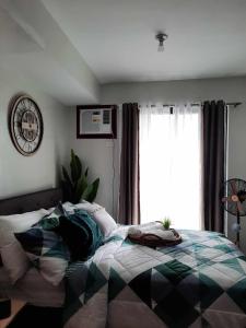 PY Suites Tagaytay في تاجيتاي: غرفة نوم بسرير ونافذة كبيرة