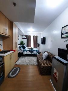 PY Suites Tagaytay في تاجيتاي: غرفة معيشة صغيرة مع أريكة ومطبخ