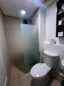 a bathroom with a white toilet and a shower at PY Suites Tagaytay in Tagaytay