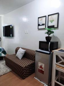 a living room with a couch and a tv at PY Suites Tagaytay in Tagaytay
