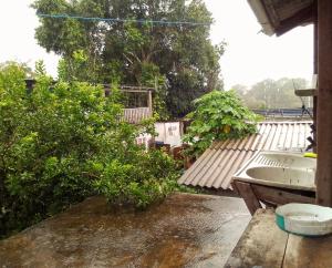 um quintal ensopado de chuva com um lavatório e árvores em Quarto compartilhado e camping na floresta em Manaus
