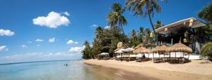 a beach with chairs and umbrellas and the ocean at Lovely 1-Bed Chalet in El Pillax Koh Lanta in Ko Lanta