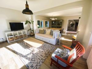a living room with a couch and a tv at Maison 5 chambres à 150 m de la plage, rénovée, jardin, proche restaurants et commerces - FR-1-481-161 in Bénodet
