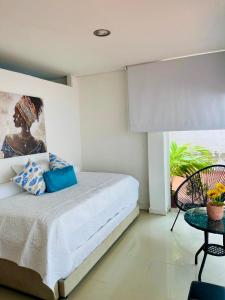a bedroom with a bed with a painting on the wall at Cerca a hotel las americas in Cartagena de Indias