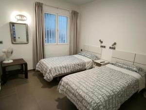 a hotel room with two beds and a window at Turina House - 3 habitaciones in Las Palmas de Gran Canaria +26 photos