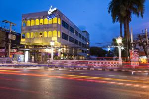 um edifício com um sinal de néon no lado de uma rua em Quip Bed & Breakfast em Cidade Phuket