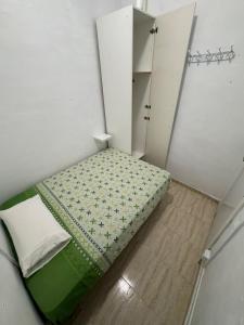 Habitación pequeña con cama y armario en SAN Rafael, en Barcelona
