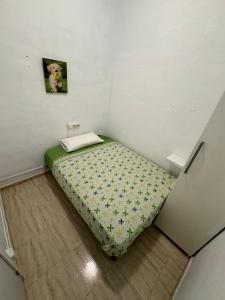 ein kleines Schlafzimmer mit einem Bett in der Ecke in der Unterkunft SAN Rafael in Barcelona