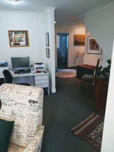 a living room with a couch and a desk at The Rise in Napier