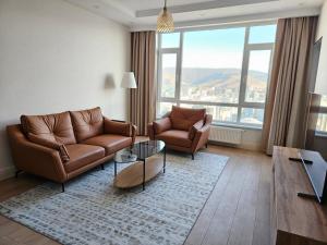 sala de estar con sofá, sillas y mesa en Fully furnished apartment fantastic view city center, en Ulán Bator