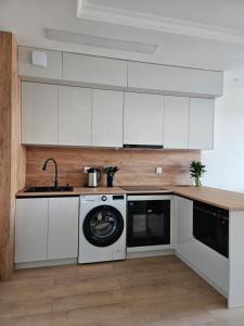 a kitchen with white cabinets and a washing machine at Fully furnished apartment fantastic view city center in Ulaanbaatar