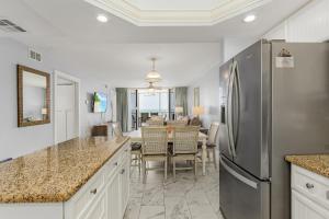 a kitchen with a stainless steel refrigerator and a dining room at Fantastic Gulf Front Condo on the North End of the Island - Beach Villas # 504 condo in Fort Myers Beach