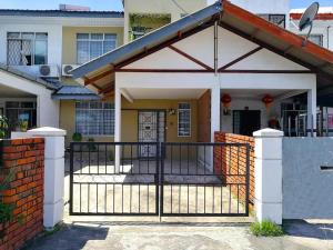 a gate in front of a house with a fence at Cozy home@Friendship Garden 3 in Kota Kinabalu