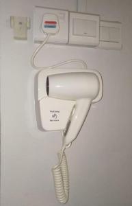 a white hair dryer hanging from a wall at Cozy home@Friendship Garden 3 in Kota Kinabalu