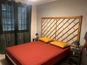- une chambre avec un grand lit rouge et des oreillers jaunes dans l'établissement TEMEHANI, à Arue