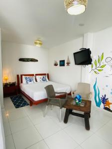1 dormitorio con cama, mesa y TV en CONNOLLY'S APARTMENTS en San Andrés
