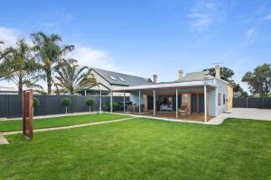 una casa con un césped verde delante de ella en Stanley Stay - Adelaide 3 Bdrm, Central Location, WiFi, en Woodville