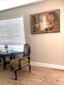 una habitación con una silla, una mesa y una pintura en Oak Cottages 6, en Rockport