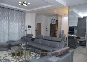 - un salon avec un canapé et une table dans l'établissement Margi Homes, à Apapa Eleko