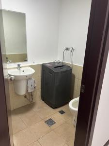 een badkamer met een wastafel, een toilet en een spiegel bij unit 23 greenhills, annapolis metro manila in Manilla