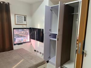 a room with a bed and a tv and a window at unit 23 greenhills, annapolis metro manila in Manila