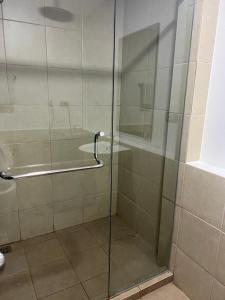 een douche met een glazen deur in de badkamer bij unit 23 greenhills, annapolis metro manila in Manilla