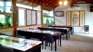 六龜區的住宿－國蘭花園VILLA會館，用餐室设有桌椅和窗户。