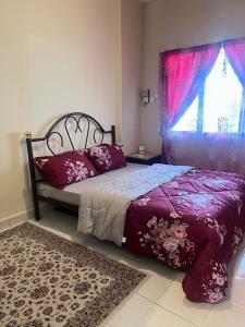 een slaapkamer met een bed met paarse lakens en een raam bij Apartment Seri Bulan Teluk Kemang Port Dicson Beach View in Kampong Tanah Merah