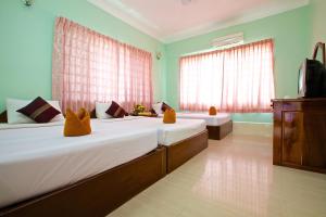 sypialnia z 2 łóżkami i telewizorem w obiekcie Damnak Riverside Villa w Siem Reap