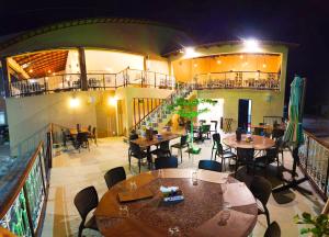 a restaurant with tables and chairs and a staircase at Premium Hotel in Mombaça